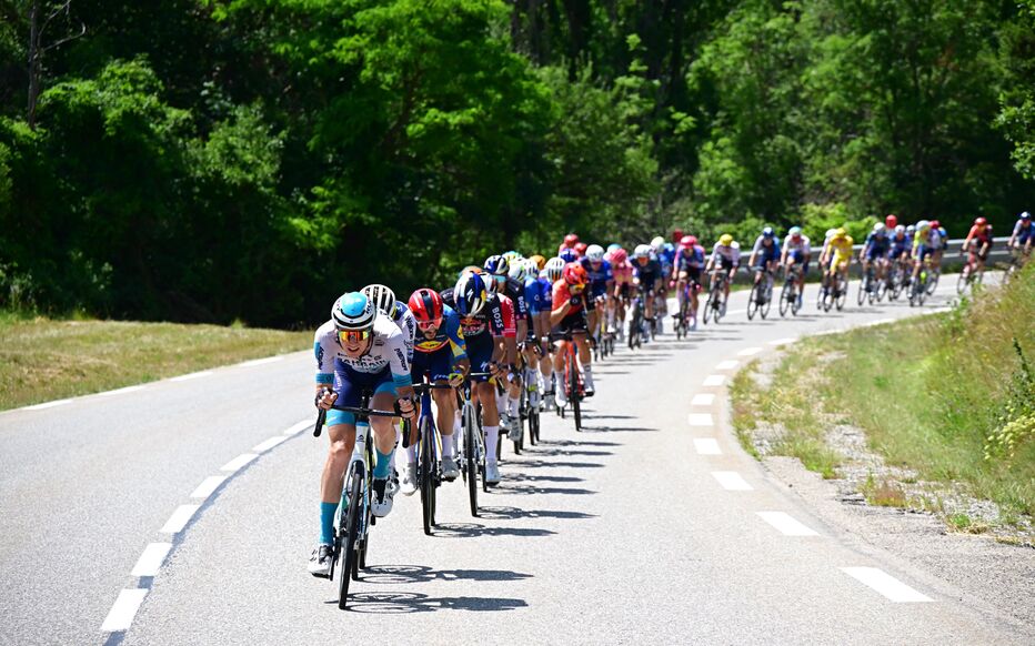 Small breakaway group riding cohesively on a flat section with gap to main field