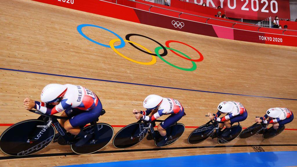Solo rider in aggressive aero time trial position with aerodynamic helmet and deep-section wheels