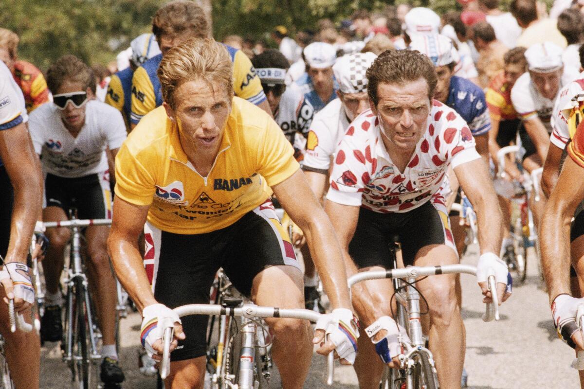 Greg LeMond climbing out of the saddle on a steep mountain pass showing sustained climbing power