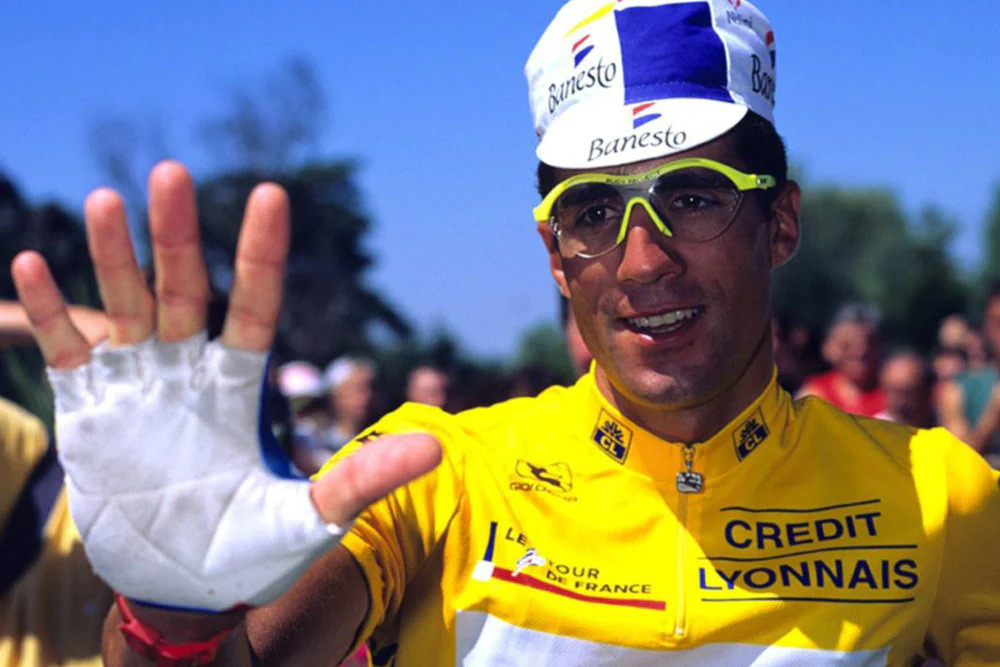 Miguel Indurain riding at a steady, measured pace with data overlays representing power and cadence