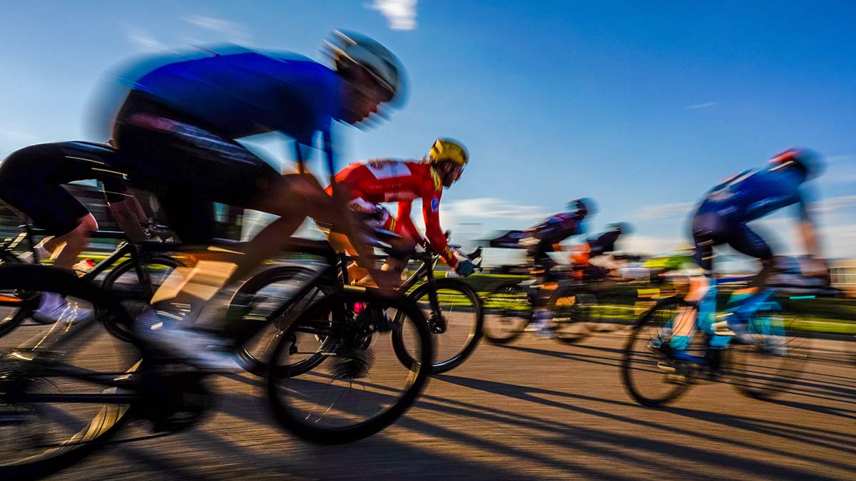 A lead team riding in a tight paceline on flat terrain controlling the peloton